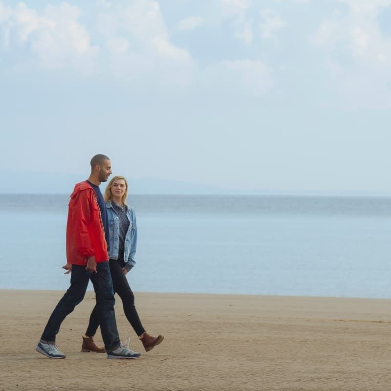 Couple Walking Along Saundersfoot Coast in West Wales Pembrokeshire